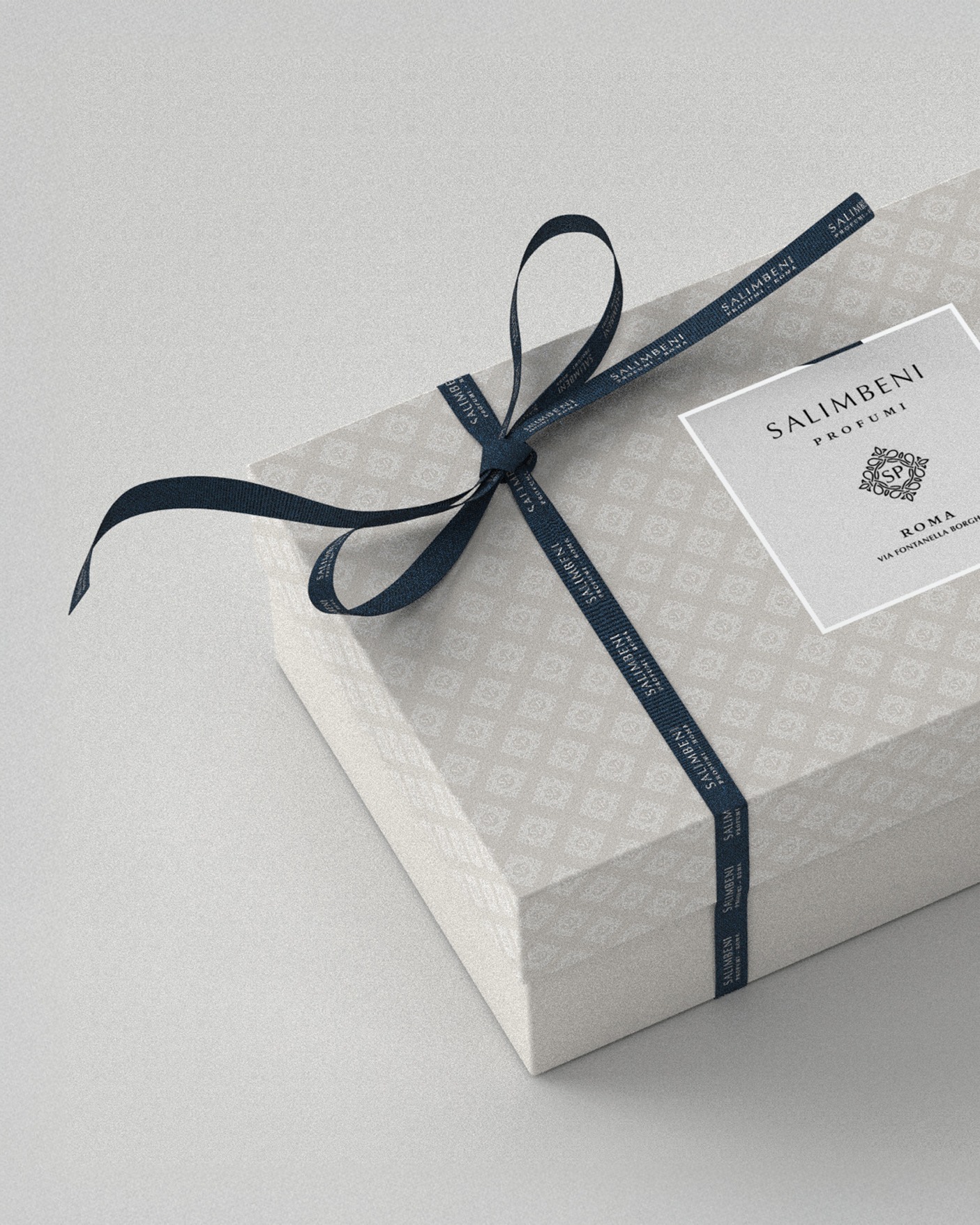 Confezione Salimbeni di tre quarti, carta decorata e nastro in tessuto blu